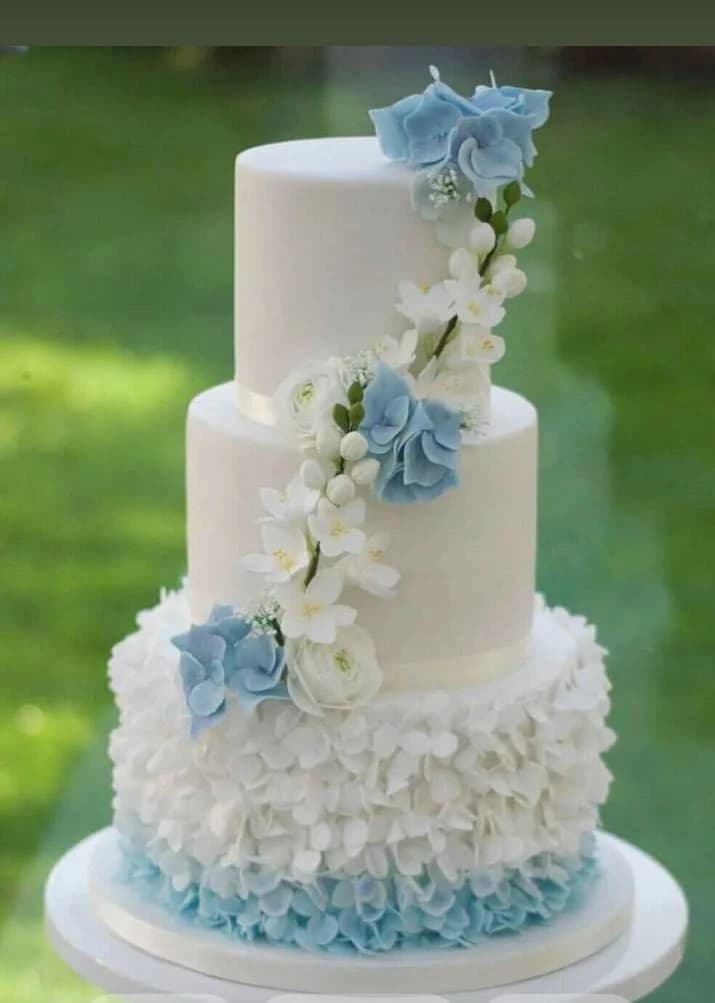 Elegant three-tier wedding cake with blue floral design