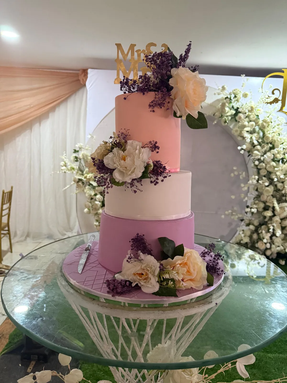 Three-tier wedding cake elegantly displayed at reception