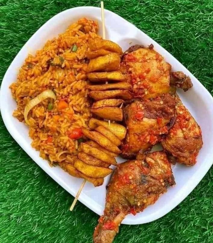 Fragrant jollof rice served with tender chicken and fried plantain